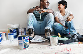 男人和女人在粉刷他们的房子时大笑