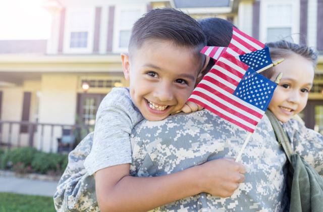 士兵拥抱拿着美国国旗的小孩