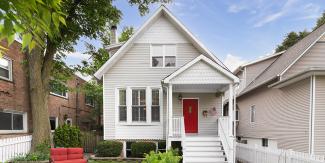 小的，可入住的灰色房子，大红色的门和户外家具